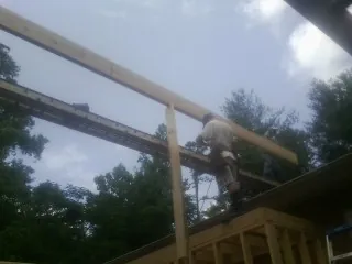 Carpenter setting a ridge beam over a new addition frame — Ice Dam Removal by Roofing Brothers in Ethel
