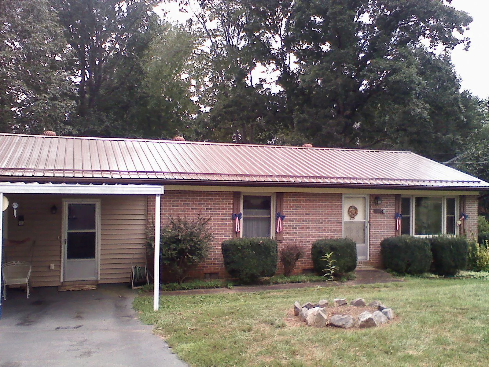 Bronze metal roof and carport on a brick ranch home — Roof Repair work by our crew in Ethel